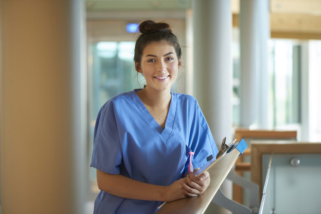 A sweet-looking young woman, who may be a graduate of the Center for Distance Education's Unit Clerk course online, is smiling at you